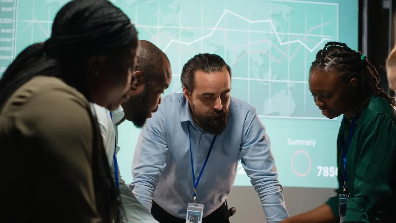 Разные коллеги присутствуют на деловой встрече в нерабочее время для анализа файлов.